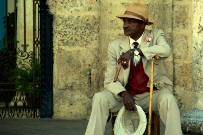 Un Cubain posé tranquillement, cigare et chapeau à la main